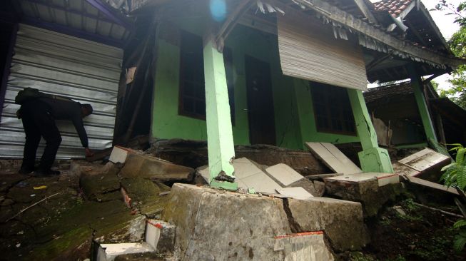 Seorang warga menunjukkan lantai rumah yang rusak parah akibat bencana tanah bergerak di Desa Dermasuci, Kabupaten Tegal, Jawa Tengah, Senin (14/2/2022).  ANTARA FOTO/Oky Lukmansyah