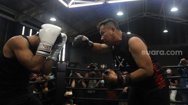 Presenter Vicky Prasetyo beradu tinju (boxing) dengan peraih medali emas PON Papua 2020 Jekson Karmela di United Gym, Cengkareng, Jakarta, Senin (14/2/2022). [Suara.com/Angga Budhiyanto]