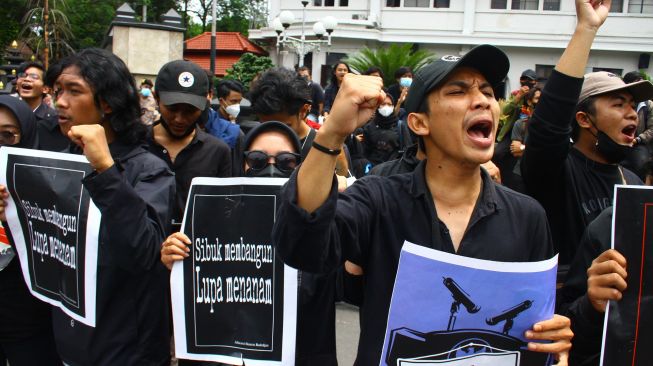 Mahasiswa yang tergabung dalam Aliansi Asura membawa poster saat berunjuk rasa di depan Balai Kota Malang, Malang, Jawa Timur, Senin (14/2/2022).  ANTARA FOTO/Ari Bowo Sucipto