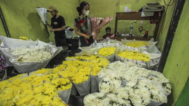 Pedagang menata buket atau karangan bunga di Pasar Bunga Rawa Belong, Jakarta, Senin (14/2/2022).  ANTARA FOTO/Reno Esnir