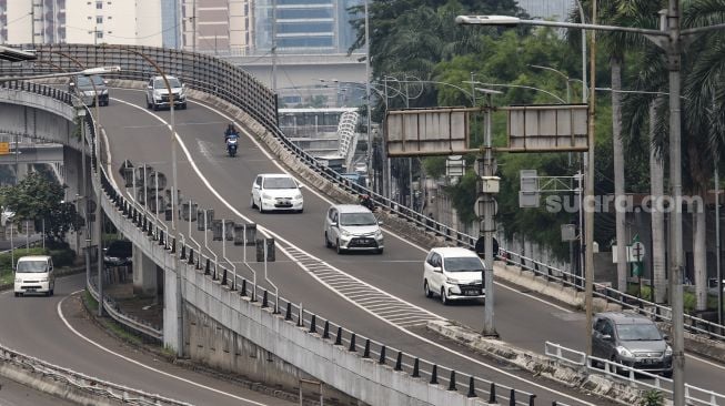 Sejumlah kendaraan melintas di Jalan Gatot Subroto, Jakarta Selatan, Selasa (15/2/2022). [Suara.com/Alfian Winanto]