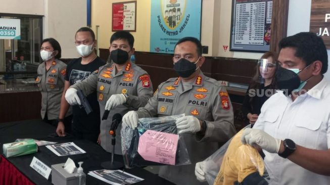 Polisi memperlihatkan barang bukti airsoft gun yang dipakai tersangka RPB (54) saat mengancam seorang kuli bangunan berinisial SE di Polres Metro Jakarta Selatan, Selasa (15/2/2022). Kasus penodongan itu terjadi di kawasan Pondok Indah. [Suara.com/Yaumal Asri Adi Hutasuhut]