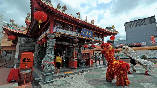 Warga Tionghoa menyaksikan atraksi barongsai secara sederhana jelang puncak perayaan 'Cap Go Meh' di Klenteng Leng Chun Keng, Jambi, Selasa (15/2/2022) malam.  ANTARA FOTO/Wahdi Septiawan
