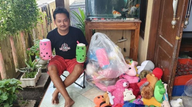 Nuryanto menunjukkan beberapa boneka hasil menyapit di rumahnya, di Jl. Kabupaten, Biru, Trihanggo, Gamping, Sleman, Rabu (16/2/2022). [Hiskia Andika Weadcaksana / SuaraJogja.id]