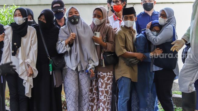 Tangis keluarga saat prosesi pemakaman Artis Dorce Gamalama di TPU Bantar Jati, Cipayung, Jakarta Timur, Rabu (16/2/2022). [Suara.com/Alfian Winanto]