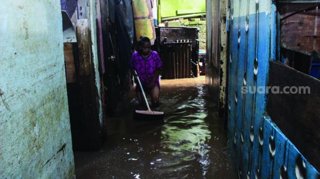 Warga permukiman kebon pala berkativitas saat banjir di Kampung Melayu, Jatinegara, Jakarta Timur, Kamis (17/2/2022). [Suara.com/Septian]