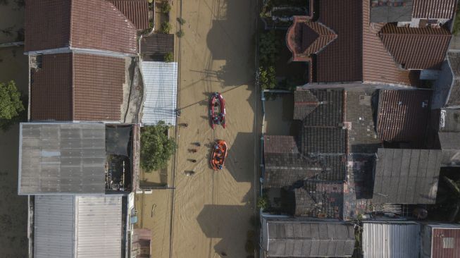 Foto udara dua perahu relawan gabungan mengevakuasi warga saat banjir di Pondok Gede Permai, Bekasi, Jawa Barat, Kamis (17/2/2022). [ANTARA FOTO/ Fakhri Hermansyah/rwa]