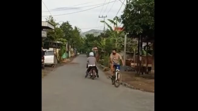 Seorang polisi menunggangi motor nyeleneh dan stop pesepeda di jalan (Facebook)