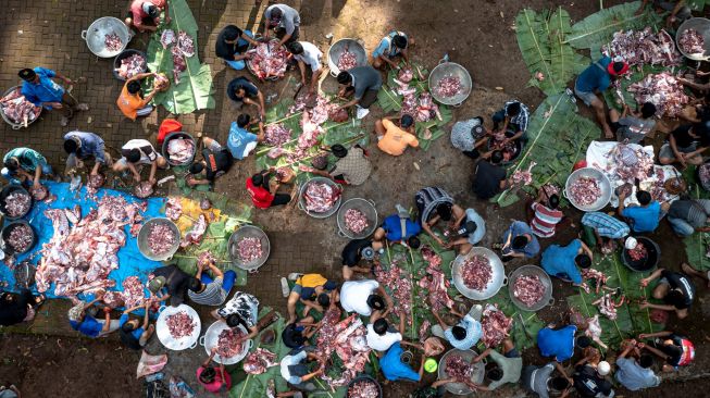 Foto udara warga bergotong royong menyortir daging kambing untuk dimasak dalam tradisi Nyadran di kompleks pemakaman Sentono, Kelurahan Ngijo, Gunungpati, Semarang, Jawa Tengah, Kamis (17/2/2021). [ANTARA FOTO/Aji Styawan/rwa]