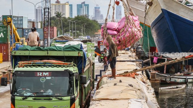 Buruh melakukan bongkar muat barang di Pelabuhan Sunda Kelapa, Jakarta Utara, Jumat (18/2/2022). [Suara.com/Alfian Winanto]