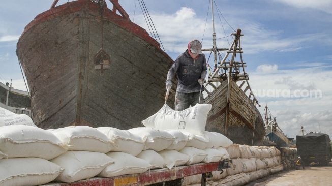 Buruh melakukan bongkar muat barang di Pelabuhan Sunda Kelapa, Jakarta Utara, Jumat (18/2/2022). [Suara.com/Alfian Winanto]