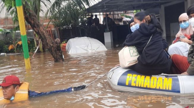 Petugas Damkar DKI Jakarta mengevakuasi warga korban banjir akibat curah hujan dan meluapnya Kali Mampang, Sabtu (20/2/2021). [ANTARA/Laily Rahmawaty]