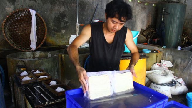 Perajin membuat tahu dari kedelai impor di Mulyorejo, Malang, Jawa Timur, Jumat (18/2/2022).  ANTARA FOTO/Ari Bowo Sucipto
