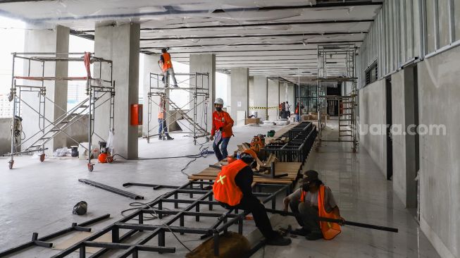 Pekerja menyelesaikan pembangunan proyek revitalisasi Taman Ismail Marzuki di Cikini, Jakarta Pusat, Jumat (18/2/2022). [Suara.com/Alfian Winanto]