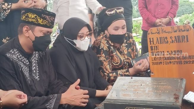 Doddy Sudrajat dan Puput Sudrajat di pemakaman sang ayah di TPU Malaka, Pondok Kopi Jakarta Timur, Jumat (18/2/2022). [Rena Pangesti/Suara.com]