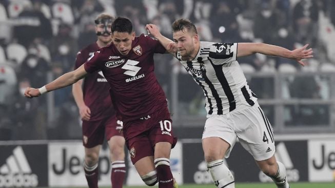 Gelandang Torino asal Serbia, Sasa Lukic (kiri) berebut bola dengan bek Juventus, Matthijs De Ligt selama pertandingan pekan ke-26 Liga Italia antara Juventus vs Torino di stadion Allianz di Turin, pada Sabtu (19/2/2022) dini hari WIB.Filippo MONTEFORTE / AFP.