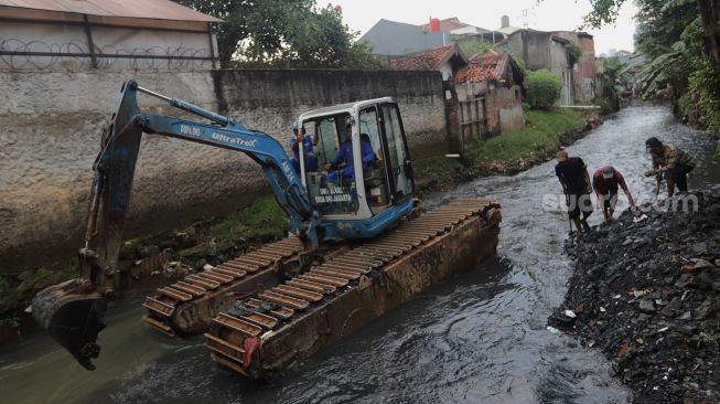 Petugas mengoperasikan alat berat saat melakukan pengerukan di Kali Mampang, Pondok Jaya, Jakarta, Sabtu (19/2/2022). [Suara.com/Angga Budhiyanto]