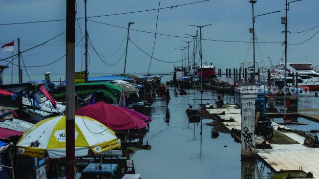 Aktivitas warga sekitar saat banjir Rob di pelabuhan Muara Angke, Jakarta Utara, Minggu (20/2/2022).  [Suara.com/Septian]