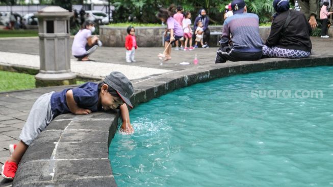 Warga beraktivitas di Taman Suropati, Jakarta Pusat, Minggu (20/2/2022). [Suara.com/Alfian Winanto]