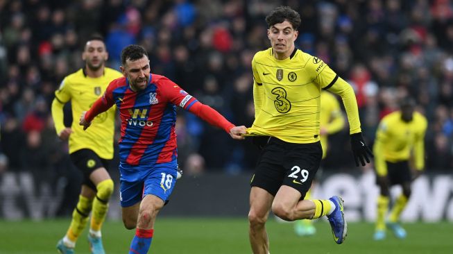 Gelandang Crystal Palace James McArthur (kiri) berebut bola dengan gelandang Chelsea Kai Havertz saat pertandingan sepak bola Liga Premier Inggris antara Crystal Palace dan Chelsea di Stadion Selhurst Park, London, Inggris, Sabtu (19/2/2022). [Glyn KIRK / AFP]