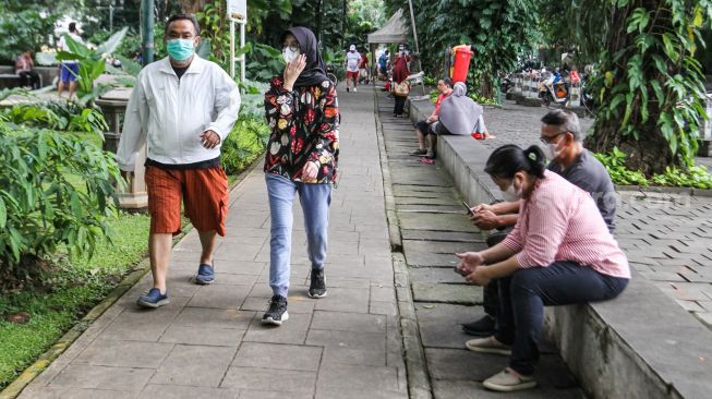 Warga beraktivitas di Taman Suropati, Jakarta Pusat, Minggu (20/2/2022). [Suara.com/Alfian Winanto]