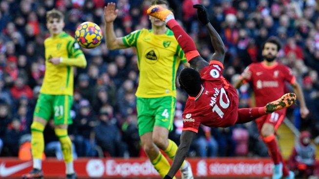 Striker Liverpool Sadio Mane mencetak gol pertama mereka dengan tembakan akrobatik saat pertandingan sepak bola Liga Premier Inggris antara Liverpool dan Norwich City di Stadion Anfield, Liverpool, Inggris, Sabtu (19/2/2022). [Oli SCARFF / AFP]