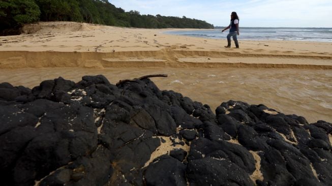 Pengunjung menikmati pemandangan di pasir pantai Parang Ireng Taman Nasional Alas Purwo, Banyuwangi, Jawa Timur, Sabtu (19/2/2022).[ANTARA FOTO/Budi Candra Setya/aww]
