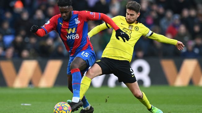 Gelandang Crystal Palace Jeffrey Schlupp (kiri) berebut bola dengan gelandang Chelsea Jorginho saat pertandingan sepak bola Liga Premier Inggris antara Crystal Palace dan Chelsea di Stadion Selhurst Park, London, Inggris, Sabtu (19/2/2022). [Glyn KIRK / AFP]
