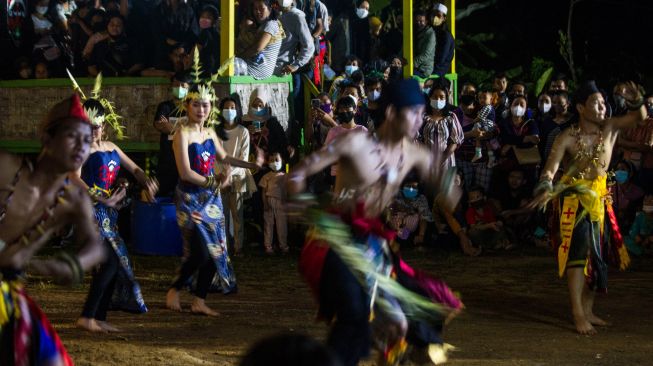 Sejumlah warga menyaksikan penari melakukan aksinya saat Festival Budaya Dayak Maanyan Warukin di Desa Warukin, Kabupaten Tabalong, Kalimantan Selatan, Sabtu (19/2/2022). [ANTARA FOTO/Bayu Pratama S/aww]