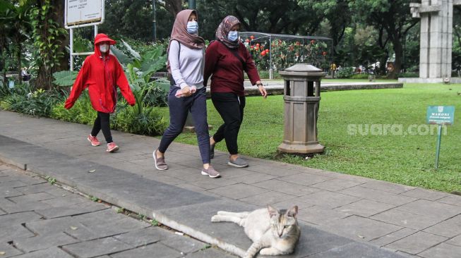 Warga beraktivitas di Taman Suropati, Jakarta Pusat, Minggu (20/2/2022). [Suara.com/Alfian Winanto]