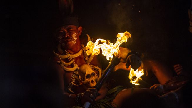 Penari melakukan atraksi api sebagai bagian Tari Atraksi Mandau Bekasai Api pada Festival Budaya Dayak Maanyan Warukin di Desa Warukin, Kabupaten Tabalong, Kalimantan Selatan, Sabtu (19/2/2022). [ANTARA FOTO/Bayu Pratama S/aww]