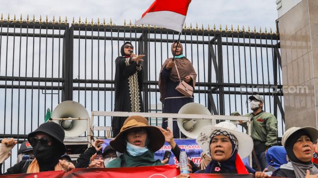 Massa yang tergabung dalam Persatuan Emak-Emak Indonesia (Permindo) menggelar unjuk rasa di depan Gedung DPR, Jakarta Pusat, Senin (21/2/2022). [Suara.com/Alfian Winanto]