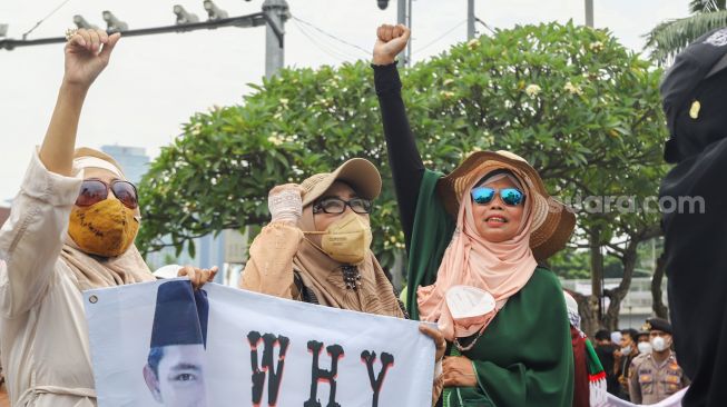 Massa yang tergabung dalam Persatuan Emak-Emak Indonesia (Permindo) menggelar unjuk rasa di depan Gedung DPR, Jakarta Pusat, Senin (21/2/2022). [Suara.com/Alfian Winanto]