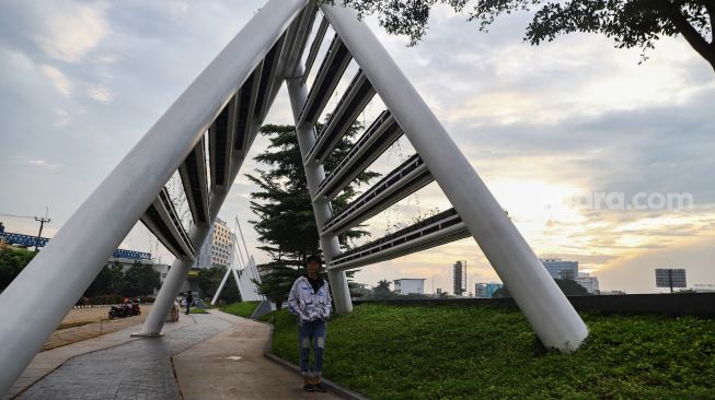 Warga saat berkunjung ke taman Tarum Bhagasasi, Kalimalang, Bekasi, Jawa Barat, Senin (21/2/2022). [Suara.com/Alfian Winanto]