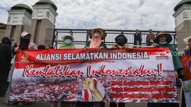 Massa yang tergabung dalam Persatuan Emak-Emak Indonesia (Permindo) menggelar unjuk rasa di depan Gedung DPR, Jakarta Pusat, Senin (21/2/2022). [Suara.com/Alfian Winanto]