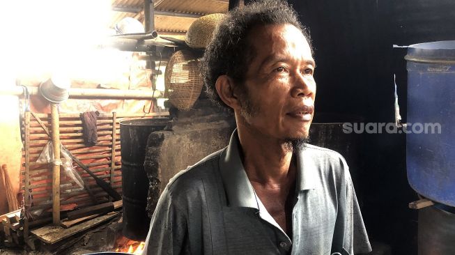 Sarbini (55), salah seorang perajin tempe di Kembangan, Jakarta Barat, Senin (21/2/2022). [Suara.com/Faqih Fathurrahman]