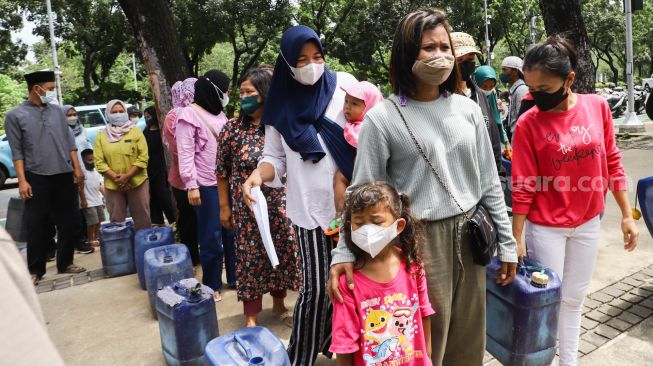 Warga Muara Angke melakukan aksi sambil membawa jeriken kosong di depan Gedung Balai Kota DKI Jakarta, Jakarta Pusat, Selasa (22/2/2022). [Suara.com/Alfian Winanto]