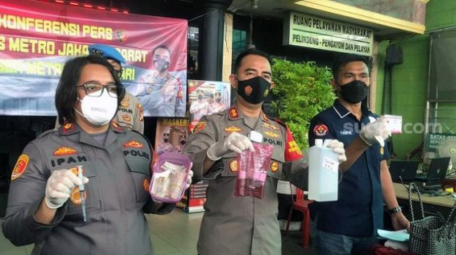 Kapolsek Metro Tamansari AKBP Rohman Yonky (tengah) memperlihatkan barang bukti kasus malpraktik yang menewaskan seorang wanita pekerja seks komersial (PSK) berinisial RCD, Selasa (22/2/2022). [Suara.com/Faqih Fathurrahman]