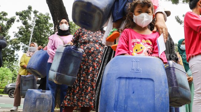 Warga Muara Angke melakukan aksi sambil membawa jeriken kosong di depan Gedung Balai Kota DKI Jakarta, Jakarta Pusat, Selasa (22/2/2022). [Suara.com/Alfian Winanto]