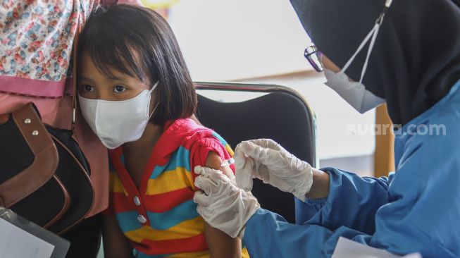 Petugas kesehatan menyuntikan vaksin Covid-19 kepada anak-anak di Pondok Pesantren Minhajurrosyidin, Jakarta Timur, Selasa (22/2/2022). [Suara.com/Alfian Winanto]