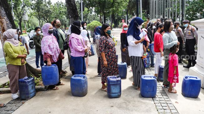 Warga Muara Angke melakukan aksi sambil membawa jeriken kosong di depan Gedung Balai Kota DKI Jakarta, Jakarta Pusat, Selasa (22/2/2022). [Suara.com/Alfian Winanto]