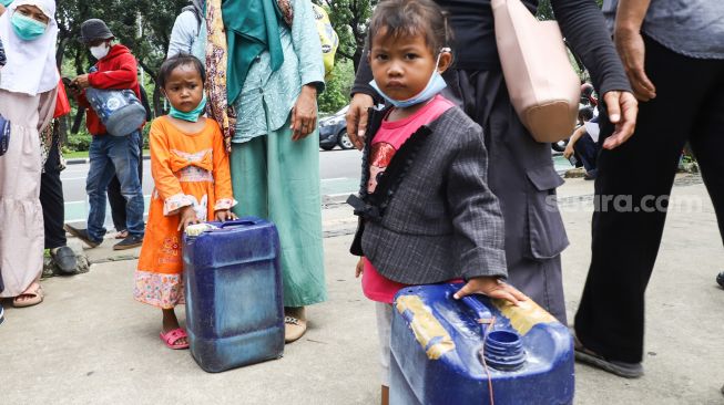 Warga Muara Angke melakukan aksi sambil membawa jeriken kosong di depan Gedung Balai Kota DKI Jakarta, Jakarta Pusat, Selasa (22/2/2022). [Suara.com/Alfian Winanto]