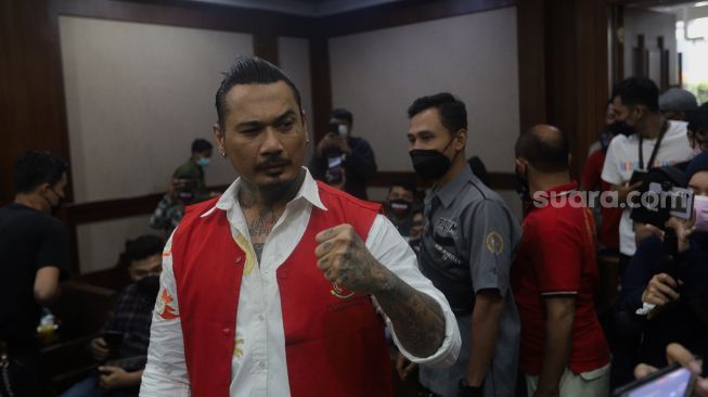 Terdakwa yang juga musisi I Gede Ari Astina atau Jerinx Superman is Dead (SID) bersiap menjalani sidang lanjutan kasus pengancaman melalui media elektronik pada Adam Deni beragendakan pleidoi atau pembacaan nota pembelaan di Pengadilan Negeri (PN) Jakarta Pusat, Jakarta, Selasa (22/2/2022). [Suara.com/Angga Budhiyanto]