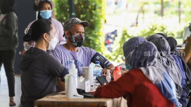 Petugas kesehatan mengecek kesehatan warga sebelum menjalani vaksinasi Covid-19 di Pondok Pesantren Minhajurrosyidin, Jakarta Timur, Selasa (22/2/2022). Petugas kesehatan menyuntikan vaksin Covid-19 kepada warga di Pondok Pesantren Minhajurrosyidin, Jakarta Timur, Selasa (22/2/2022). [Suara.com/Alfian Winanto]