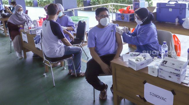 Petugas kesehatan menyuntikan vaksin Covid-19 kepada warga di Pondok Pesantren Minhajurrosyidin, Jakarta Timur, Selasa (22/2/2022). Petugas kesehatan menyuntikan vaksin Covid-19 kepada warga di Pondok Pesantren Minhajurrosyidin, Jakarta Timur, Selasa (22/2/2022). [Suara.com/Alfian Winanto]