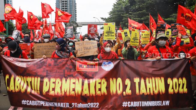 Massa buruh saat menggelar aksi unjuk rasa di depan gedung Kementerian Tenaga Kerja (Kemenaker) di Setia Budi, Jakarta Selatan, Rabu (23/2/2022). [Suara.com/Alfian Winanto]