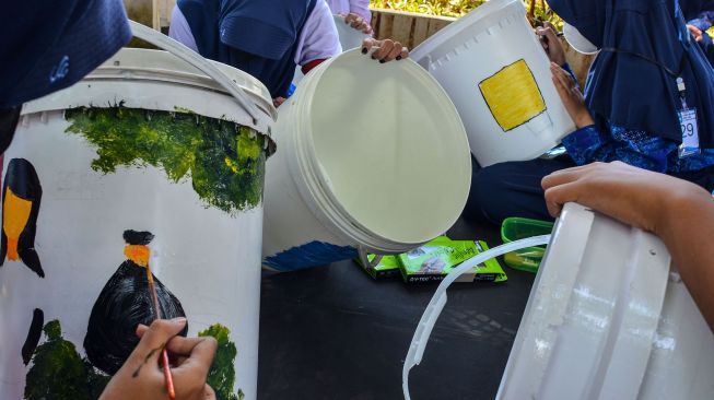 Sejumlah siswa melukis di atas media ember di Alun-alun Kota Tasikmalaya, Jawa Barat, Rabu (23/2/2022). ANTARA FOTO/Adeng Bustomi

