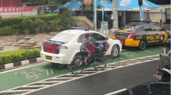 Potret Mobil Polisi Parkir di Jalur Sepeda, Publik: Harusnya Denda Kalau Kayak Gini