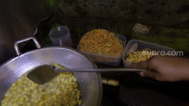 Penjual menggoreng kentang di salah satu warung di kawasan Jati Padang, Pasar Minggu, Jakarta, Rabu (23/2/2022). [Suara.com/Angga Budhiyanto] 