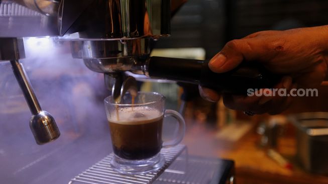 Barista meracik kopi di Toko Dunia Kopi, Pasar Santa, Jakarta, Rabu (23/2/2022). [Suara.com/Angga Budhiyanto]